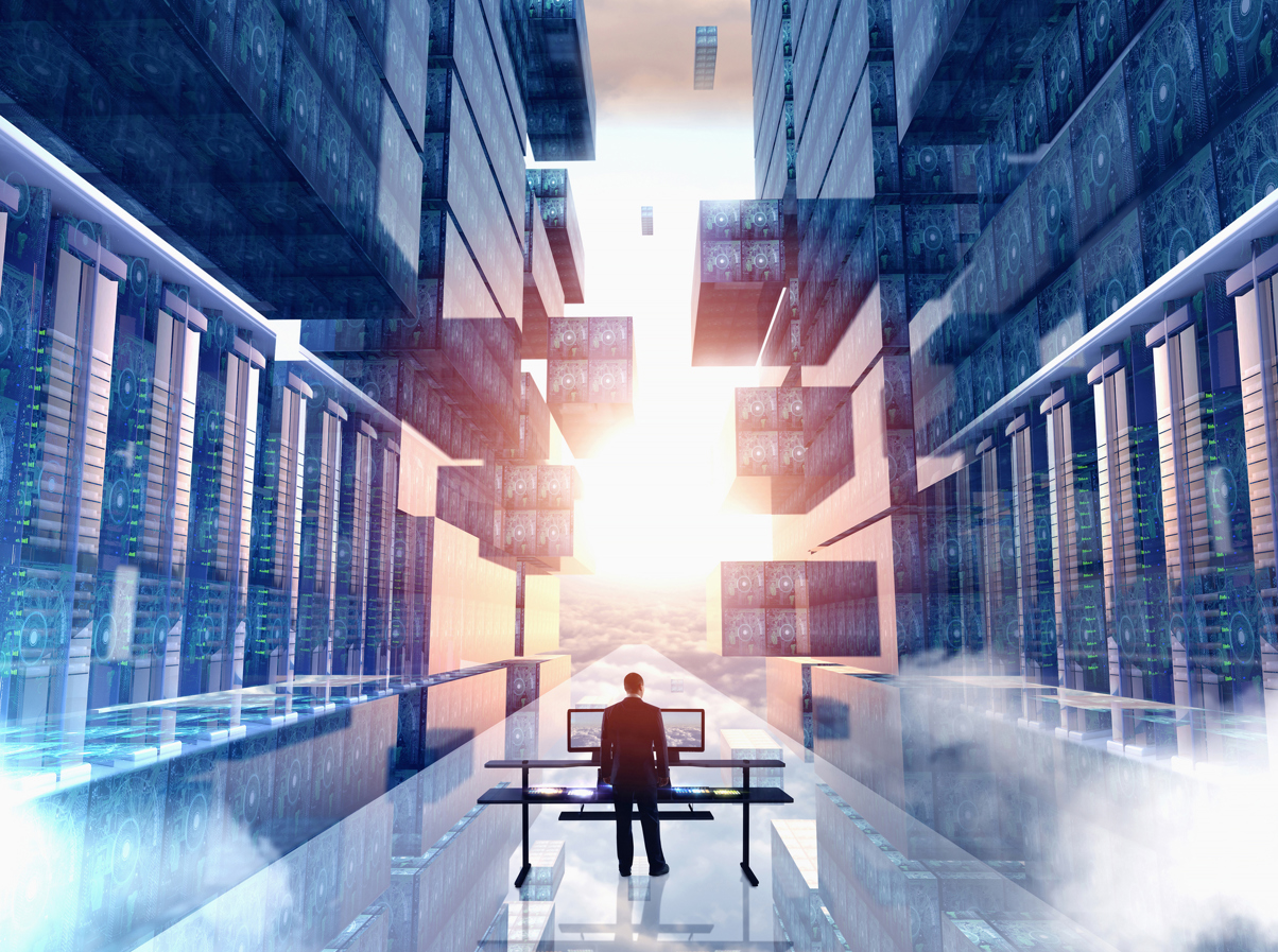 Image of a man standing in front of two computer monitors