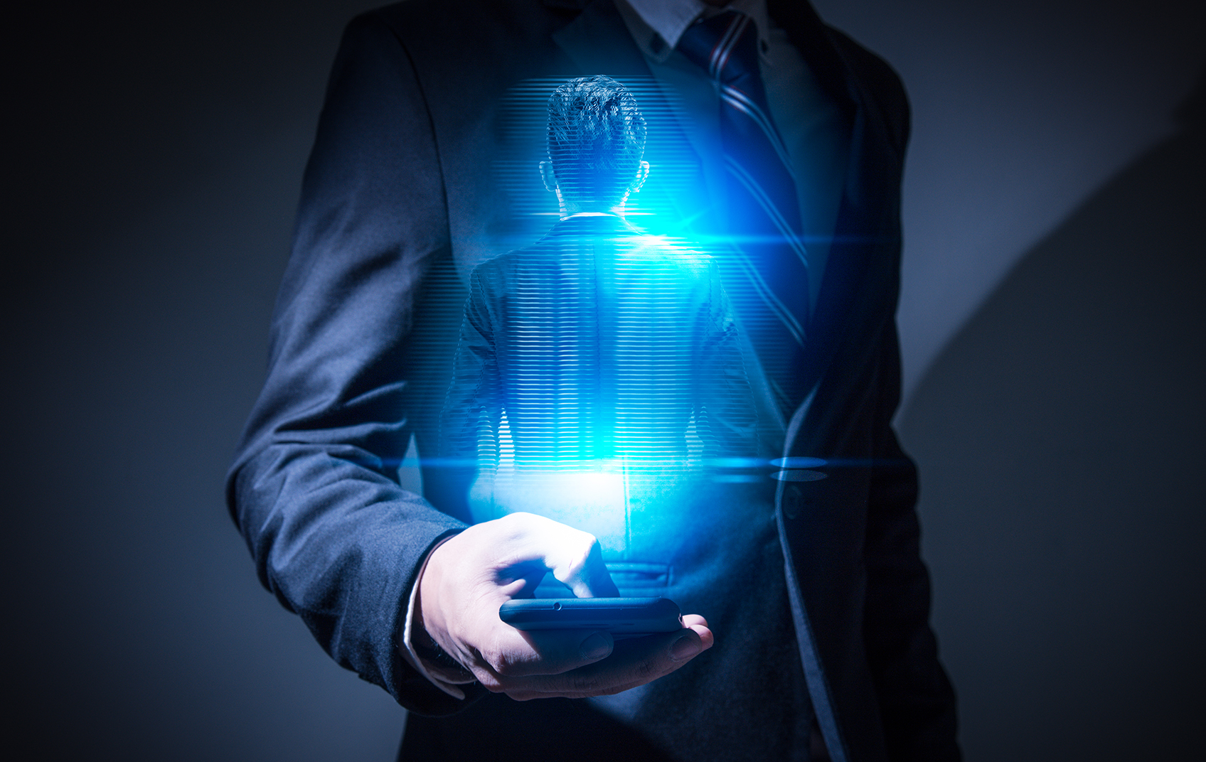 Businessman holding phone with hologram - Triggs Lecture