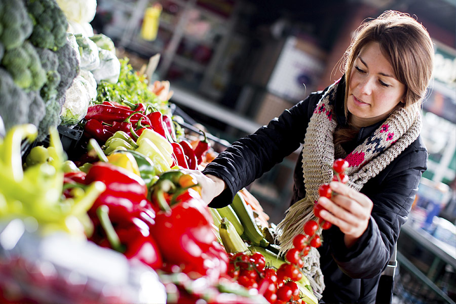 A woman picking vegetables at a market