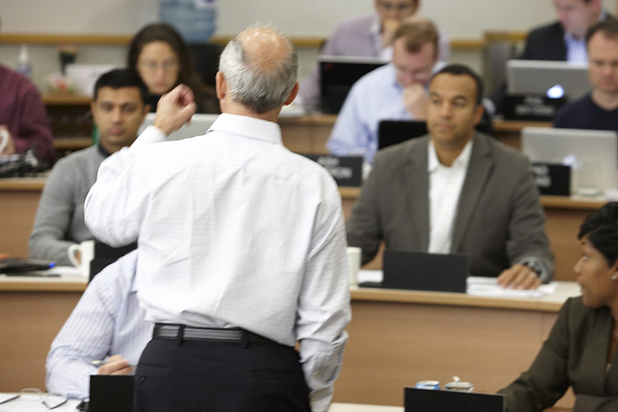 Professor lecturing to a class of students with his back to the camera