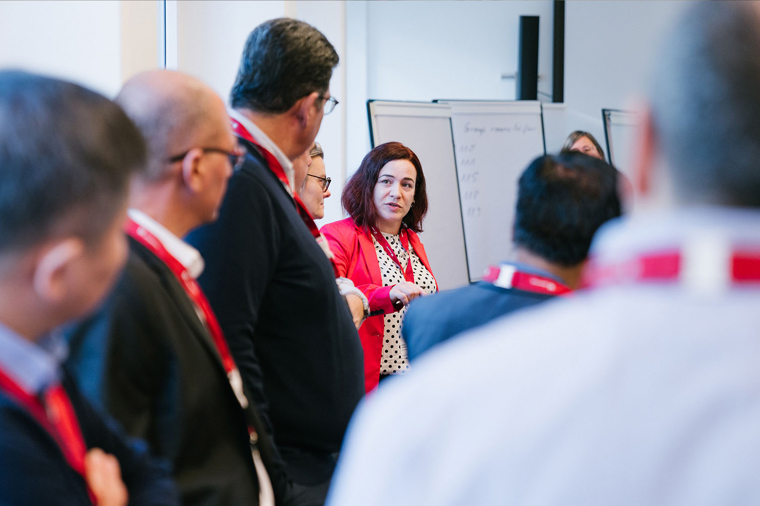An Academic Workshop With Executives Gathered Around A Whiteboard
