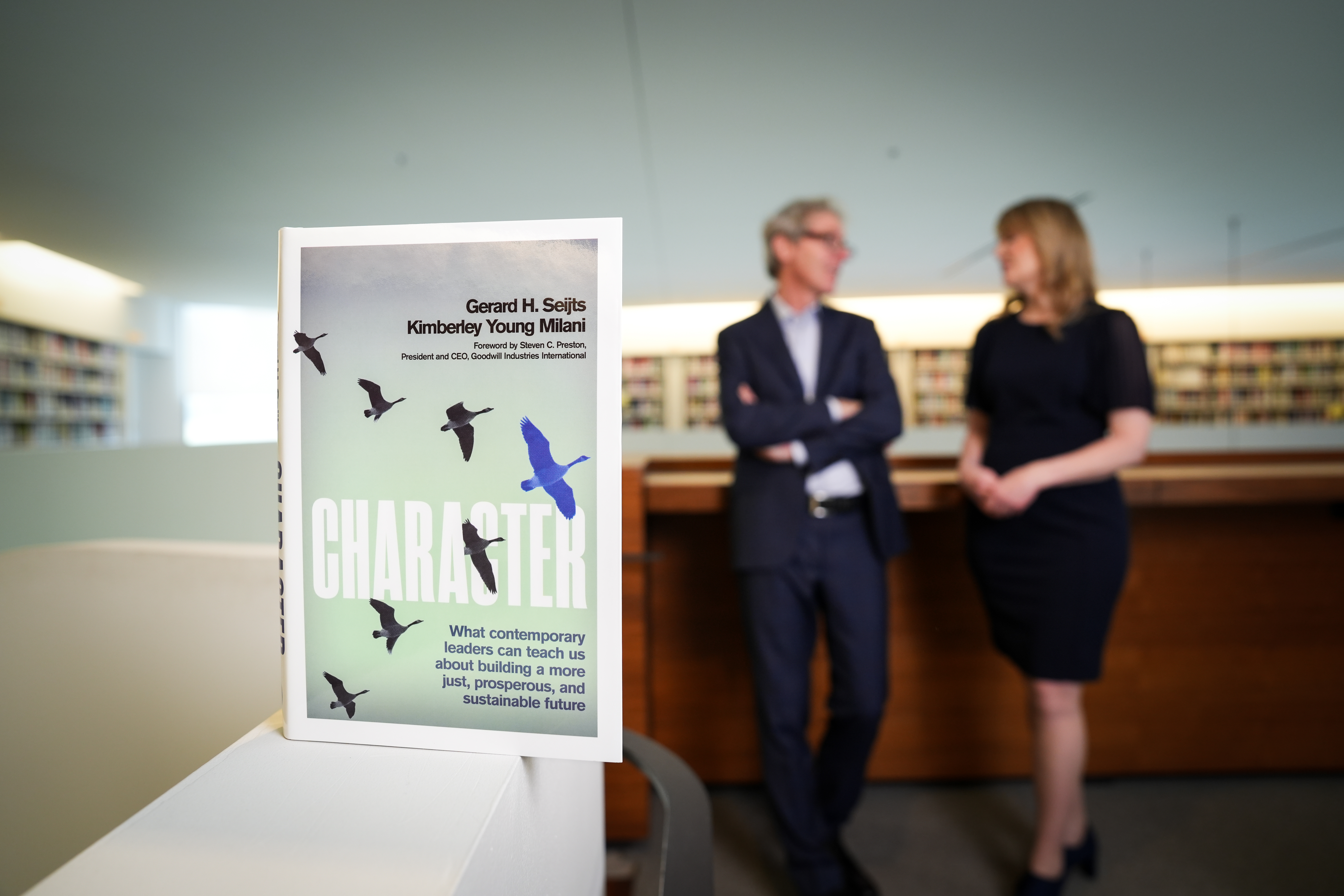 Character book on table with authors, Gerard Seijts and Kimberly Young Milani in the background