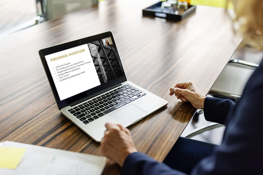 A woman watching a webinar on a laptop