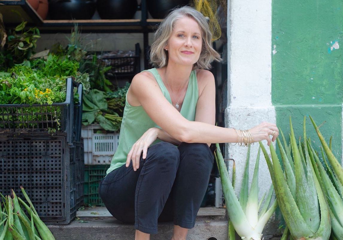 Alumna posing on steps of a market