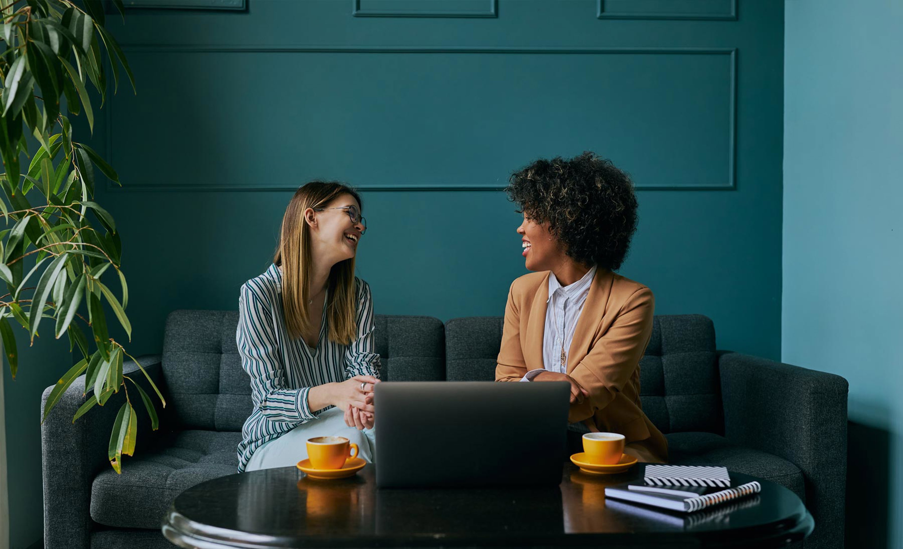 Two Professionals Smiling Over A Cup Of Coffee