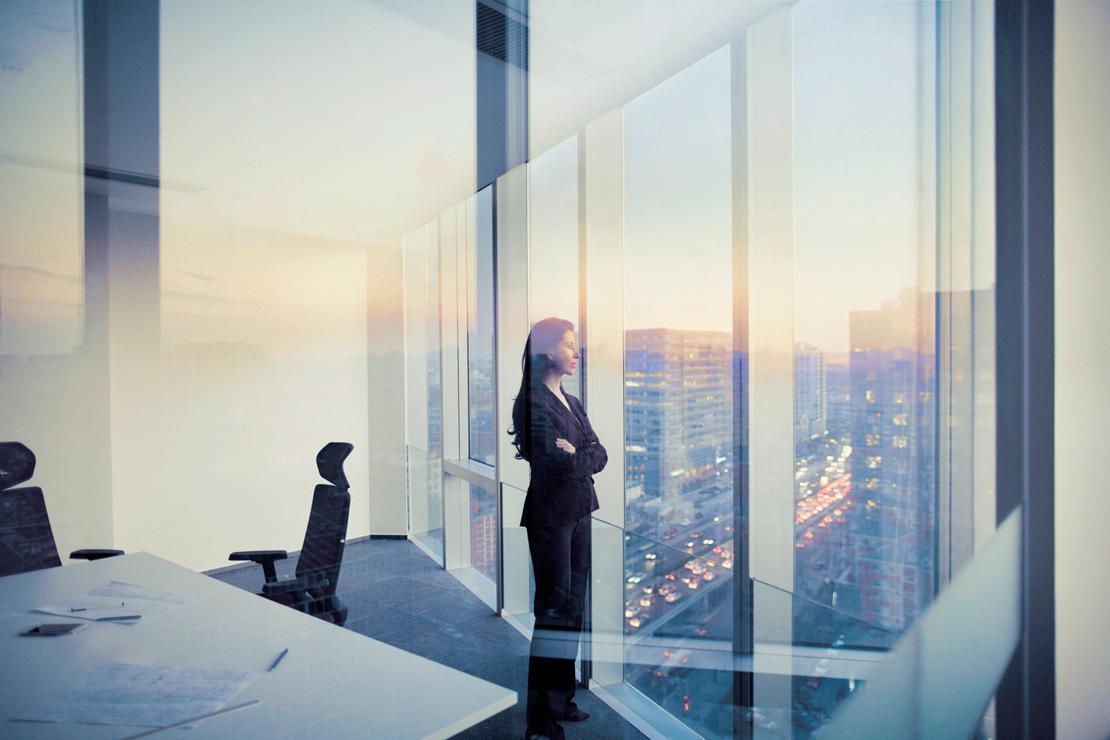 Woman in Boardroom Looking out Window