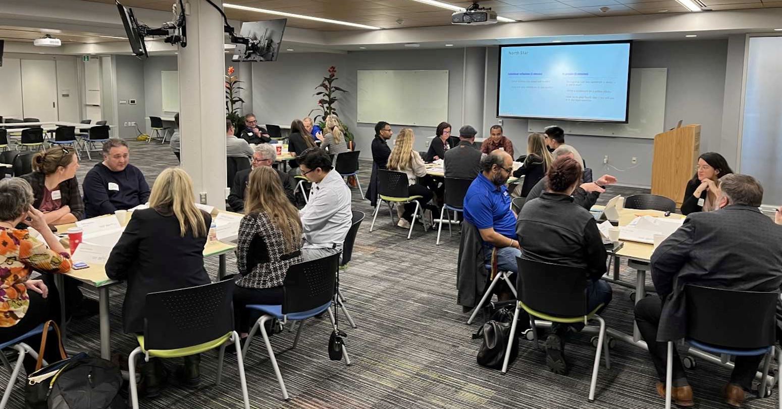 People sitting around circular tables in a classroom