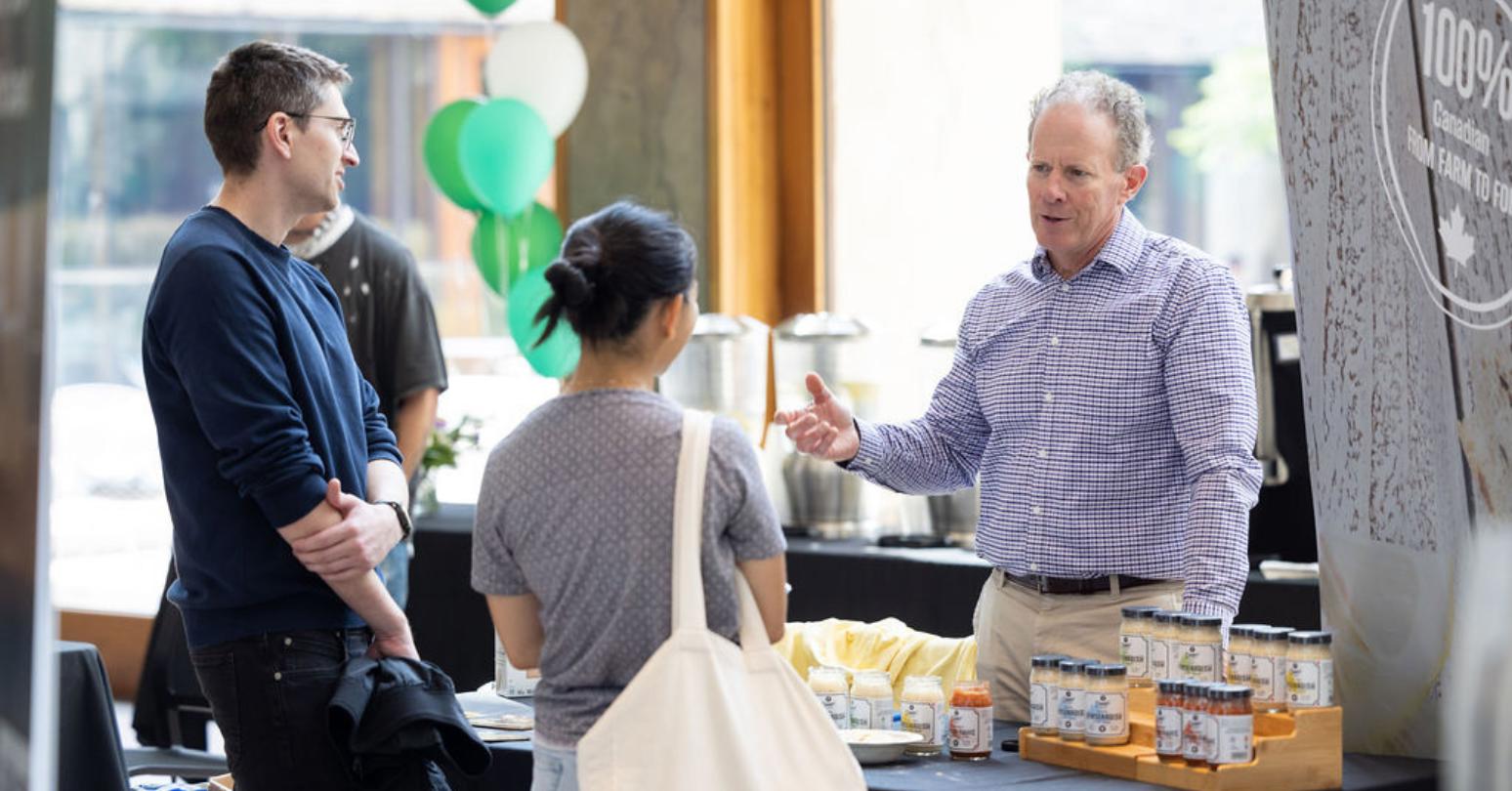 Dennis’ Horseradish co-owner Mark Whitmore, MBA '91, talking to Open House guests