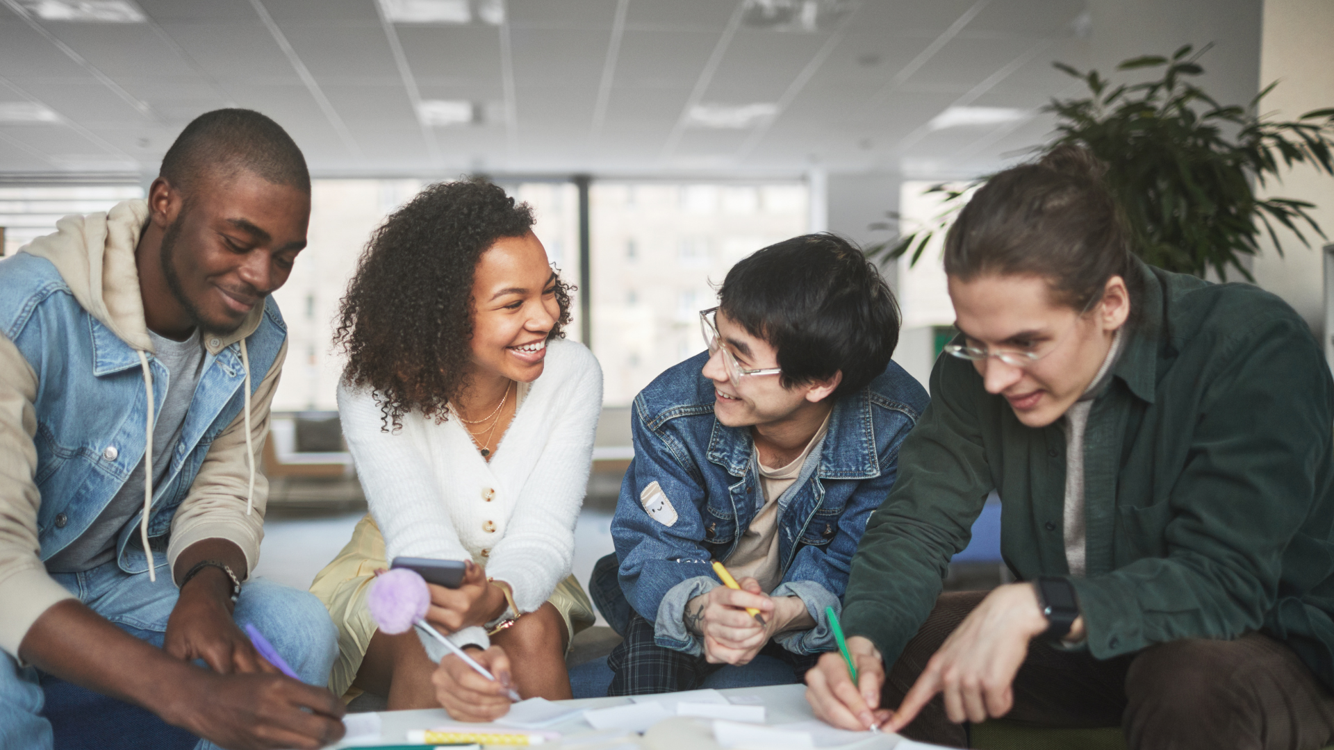 4 students talking to each other around a group project